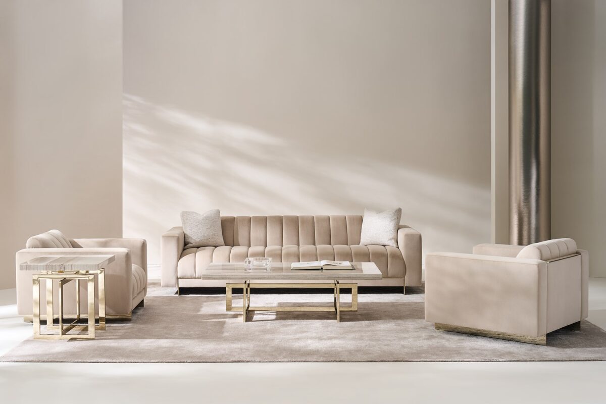 The Caracole Well Balanced Chair, featuring a tight seat and back with channel tufting, upholstered in a shimmering Moonstone basketweave fabric, and resting on a thin Whisper of Gold stainless steel frame with matching beading down the back.