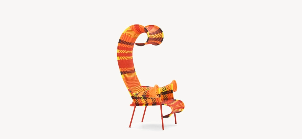 Shadowy armchair by Moroso in vibrant Multired pattern, showcasing its sculptural form and high backrest