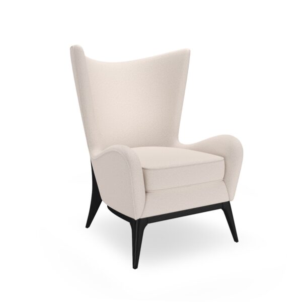 The Caracole "Whats New Pussycat?" wing chair, featuring a modern Scandinavian design with a light-colored upholstered body, gracefully sloped arms, a soft round back, and a distinctive exposed wood detail on the outback in a Modern Walnut or Almost Black finish.