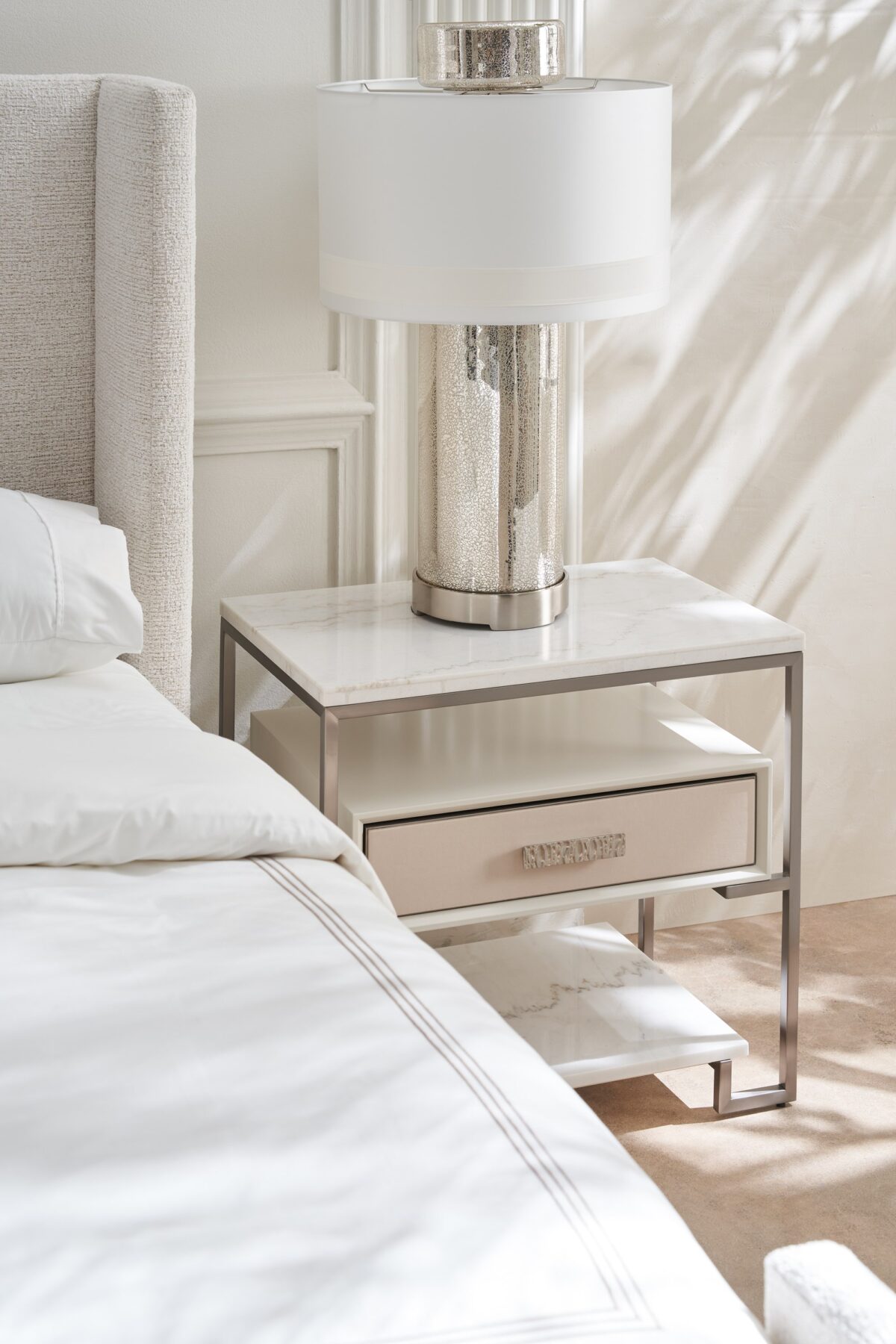 Caracole Shelter Me King Bed featuring a soft chenille upholstered headboard, footboard, and side rails, complemented by decorative buttons and a plinth base in Almost Black finish.