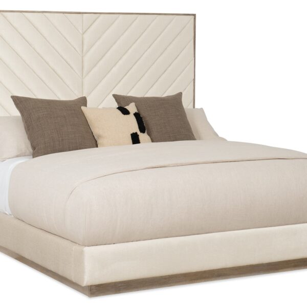 Caracole Meet U in the Middle King Bed featuring a fully upholstered frame with a chevron-patterned headboard, complemented by Ash Driftwood wood trim and a plinth base.