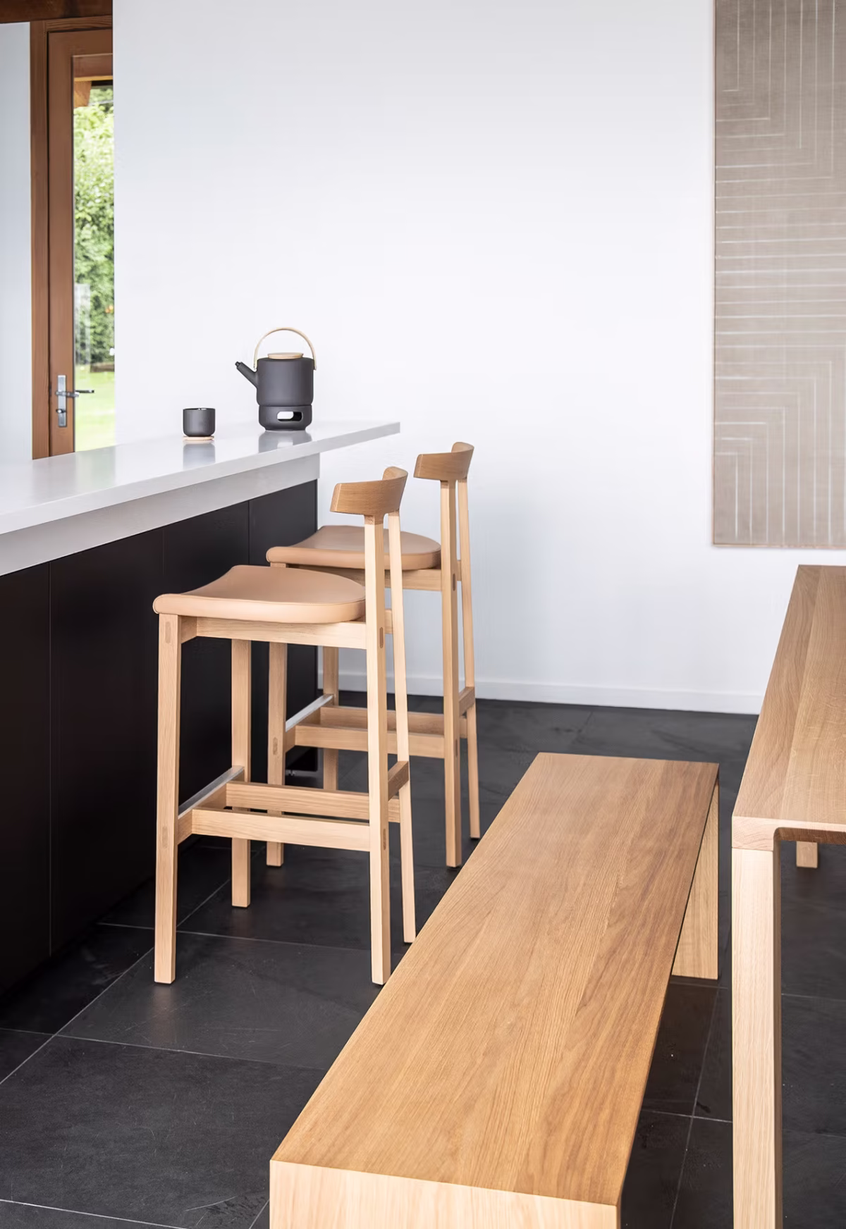 Contemporary TORII counter stool by Bensen, showcasing its sleek, understated design with a comfortable seat and slender, elegant legs.