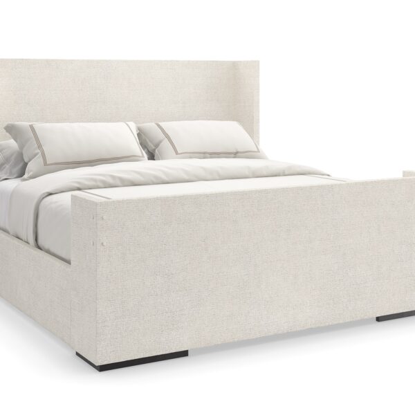 Caracole Shelter Me King Bed featuring a soft chenille upholstered headboard, footboard, and side rails, complemented by decorative buttons and a plinth base in Almost Black finish.