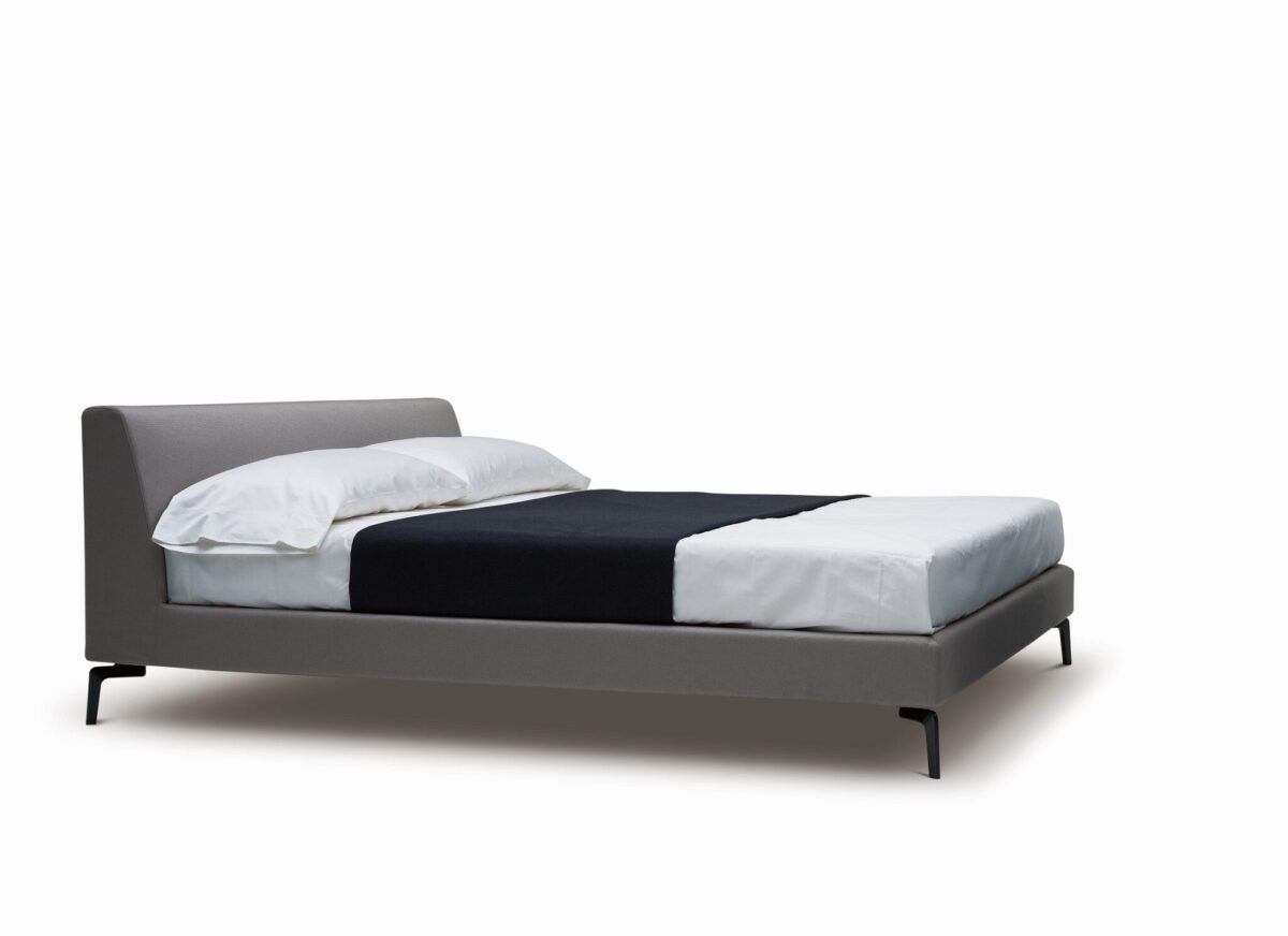 Upholstered platform bed with low profile and padded headboard by Camerichusa.