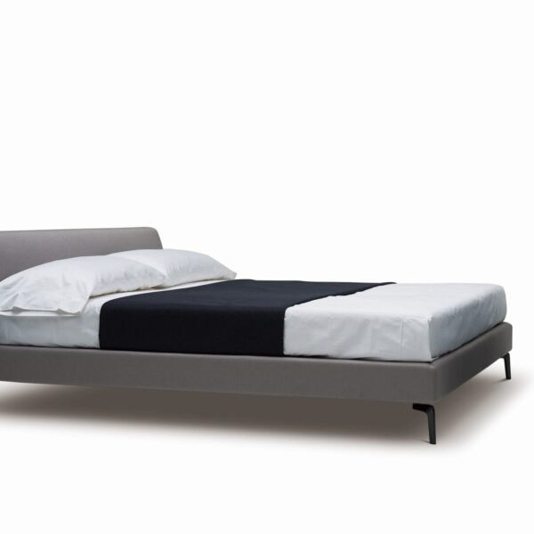 Upholstered platform bed with low profile and padded headboard by Camerichusa.