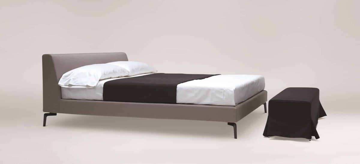 Upholstered platform bed with low profile and padded headboard by Camerichusa.