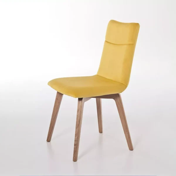 Akila chair in plum velvet with decorative button tuft on the backrest and black four-spoke swivel base, shown on a white studio floor.