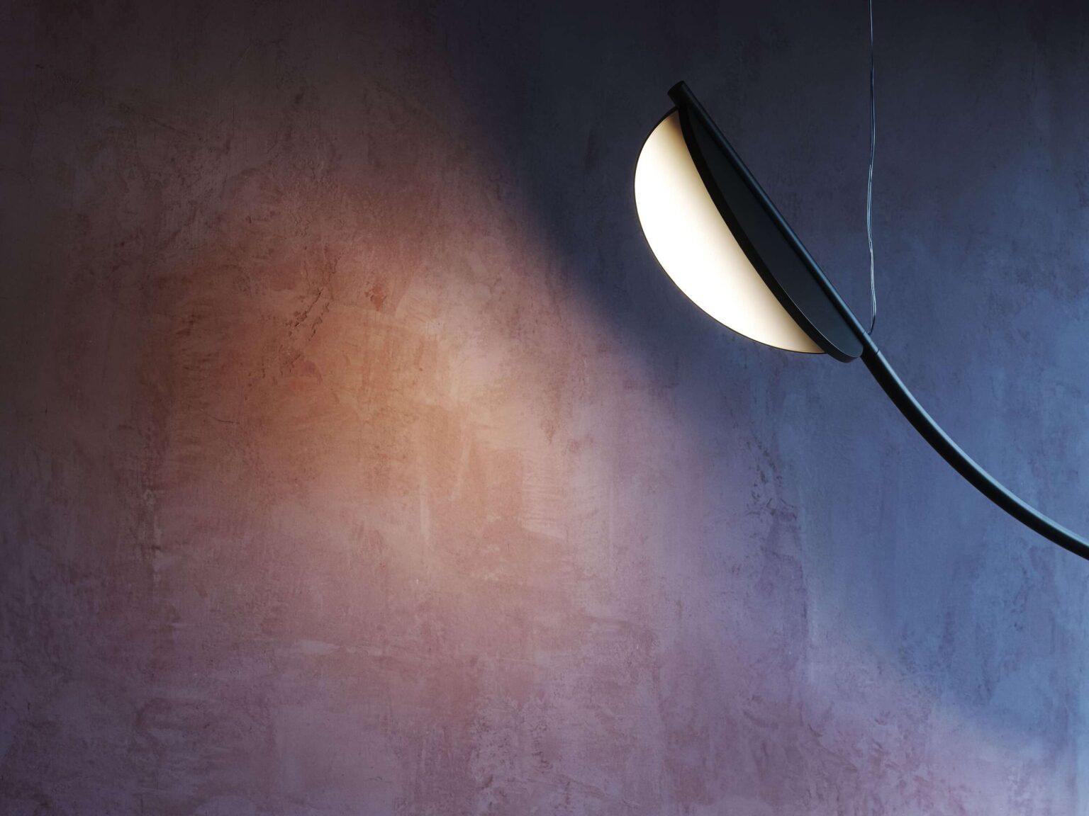 Suspension lamp in matte anthracite finish, featuring two rotating light modules on a sculptural arc.