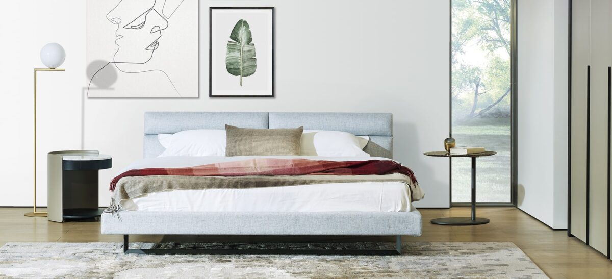 Contemporary upholstered bed with plush headboard and sleek frame by Camerichusa.