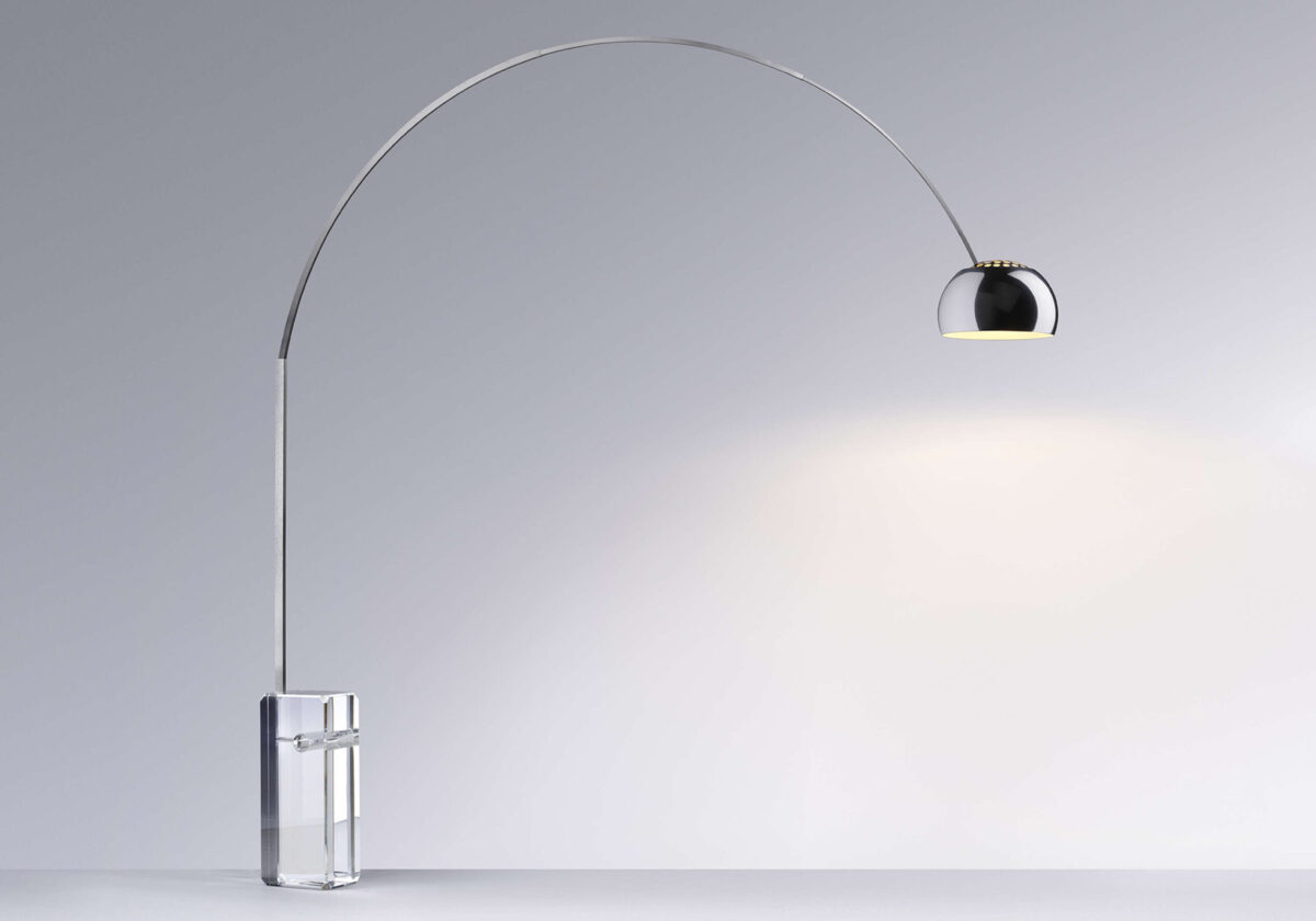 Side view of Arco K showing its sweeping arm and semi‑silver cap reflector above a sculptural glass base.