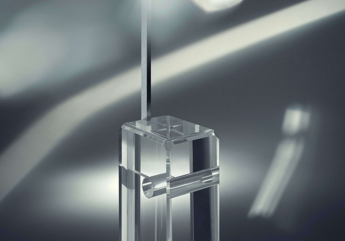 Limited‑edition Arco K with transparent lead‑free glass block base and polished stainless‑steel telescopic stem, numbered piece.