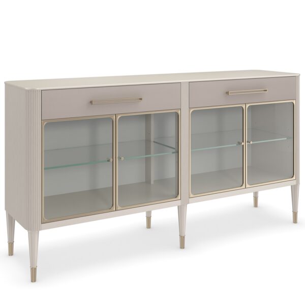 Love Interest Sideboard by Caracole in Matte Pearl finish, featuring reeded birchwood case, vinyl-wrapped drawer fronts with linear hardware, and Whisper of Gold metal ferrules. Interior boasts adjustable glass shelves with touch dimmer lighting, complemented by soft-close drawers