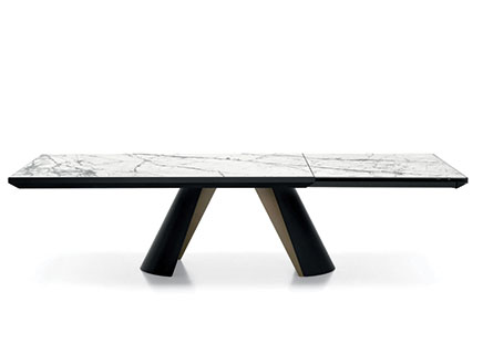 "APIAN PLUS dining table with golden metal base and large elliptical ceramic top in a modern dining room."