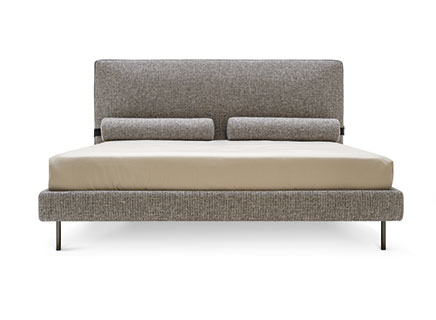 The Calligaris Mies letto, a modern upholstered bed with clean lines, showcasing its unique headboard design that can include removable bolster pillows attached magnetically.