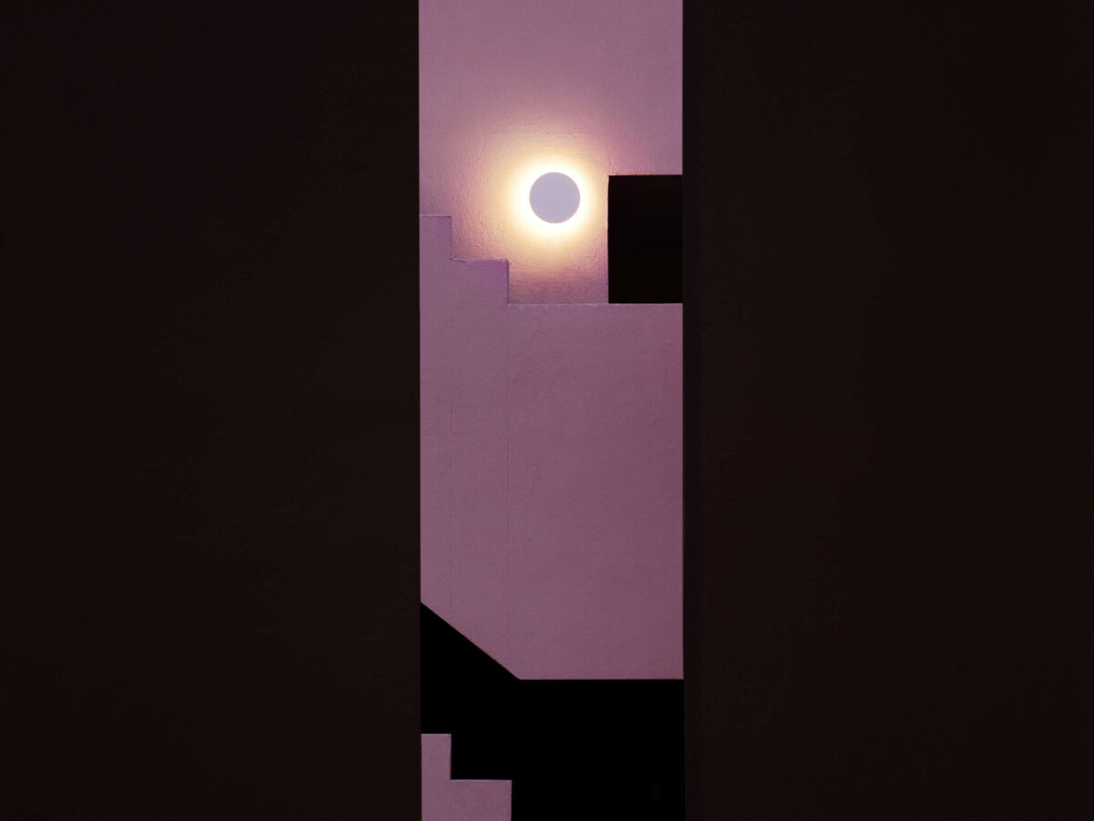 The Flos Camouflage 240mm, a sophisticated and robust IP65-rated outdoor lamp, featuring a natural Crema d'Orcia stone face that glows with diffused light from its integrated LED source.