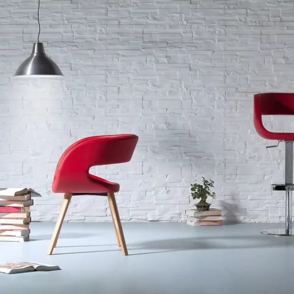 Ego chair by Peressini with a gently curved, bucket-style shell seat upholstered in light grey fabric and supported by slim black metal legs.