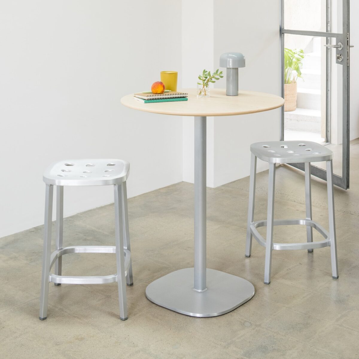 Modern aluminum chair with perforated back and seat, designed by Jasper Morrison, offering a durable and visually striking piece suitable for a variety of settings.