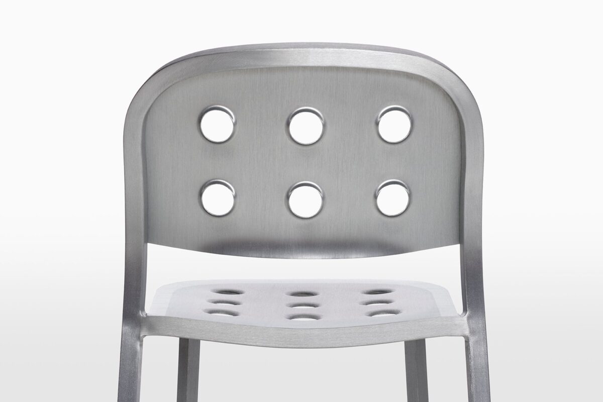 The 1 Inch All Aluminum Chair by Jasper Morrison combines practicality and style with its perforated aluminum seat, ideal for contemporary interiors and exteriors.