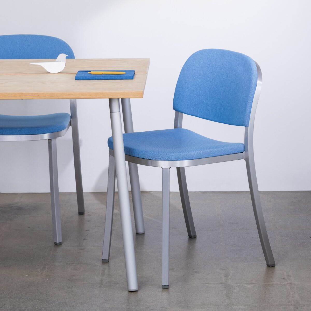 Emeco 1 Inch Side Chair with upholstered seat, sleek aluminum frame.