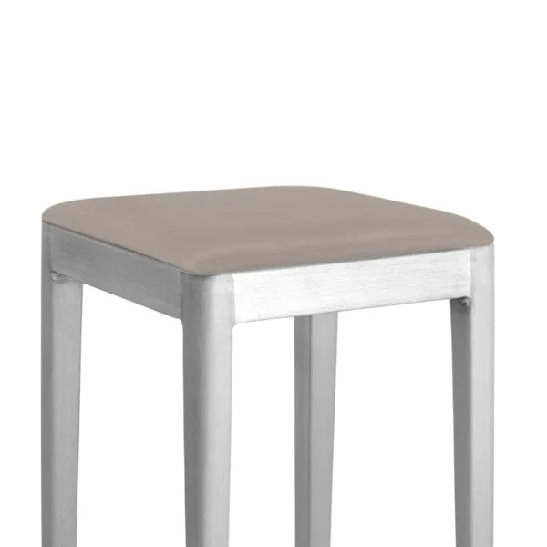 Za Mini Stool in dark grey by Emeco, designed by Naoto Fukasawa, features a compact recycled aluminum frame with a powder-coated finish, suitable for both indoor and outdoor use.