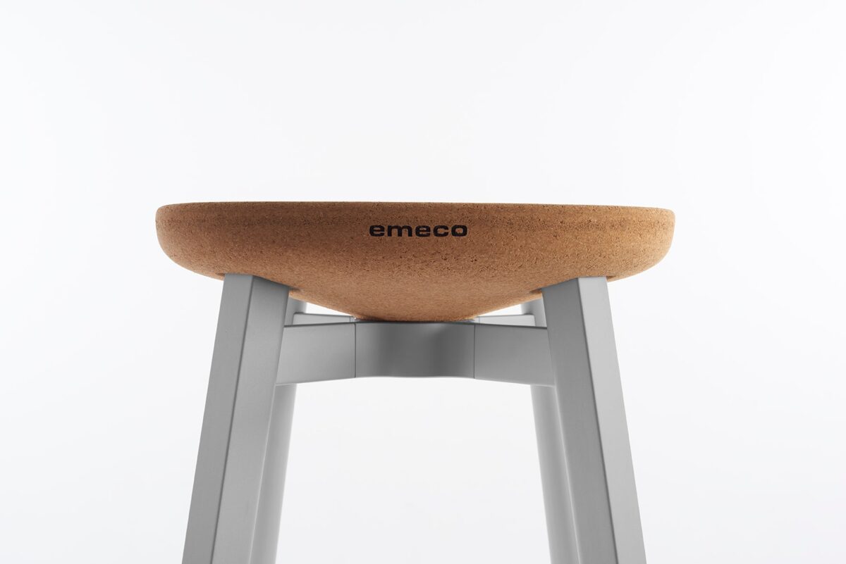 Emeco's SU Small Stool designed by Nendo, featuring a simple oak seat and lightweight aluminum legs.