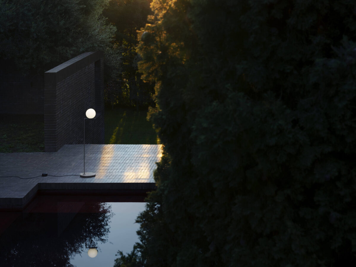 Side view of the IC F1 Outdoor H 1350 mm lamp by Flos, standing on a patio with soft ambient lighting.