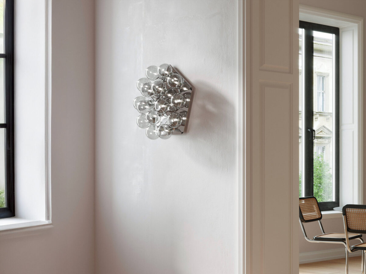 A modern chandelier-like Flos Taraxacum 88 Ceiling & Wall lamp, featuring an exposed array of 15 globe bulbs on a triangular, polished aluminum structure, designed for a dramatic visual impact.