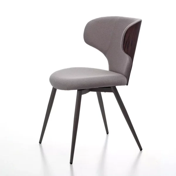 Luna W stool in beige fabric with gently curved backrest, cast‑iron gas‑lift column, and square stainless‑steel base on a showroom floor.