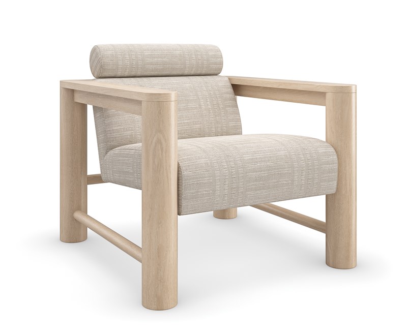 Caracole Unity Lounge Chair, featuring a pillared Sun Drenched Oak wood frame, light-colored upholstered seat and back, and a distinctive Lucent Bronze Metallic metal plate on the backrest.