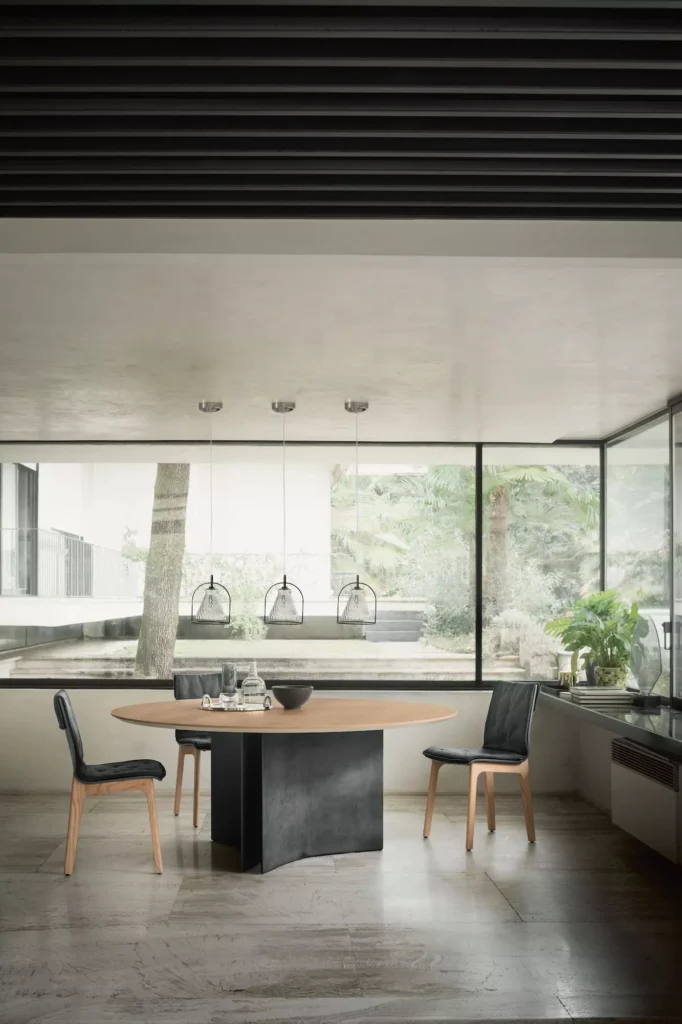 Elegant Magnum dining table by Bontempi in walnut veneer and sleek white concrete base in a modern living space.