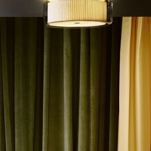“Contemporary table lamp Mercer by Marset – elegant contrast of warm fabric and clear glass cylinder”