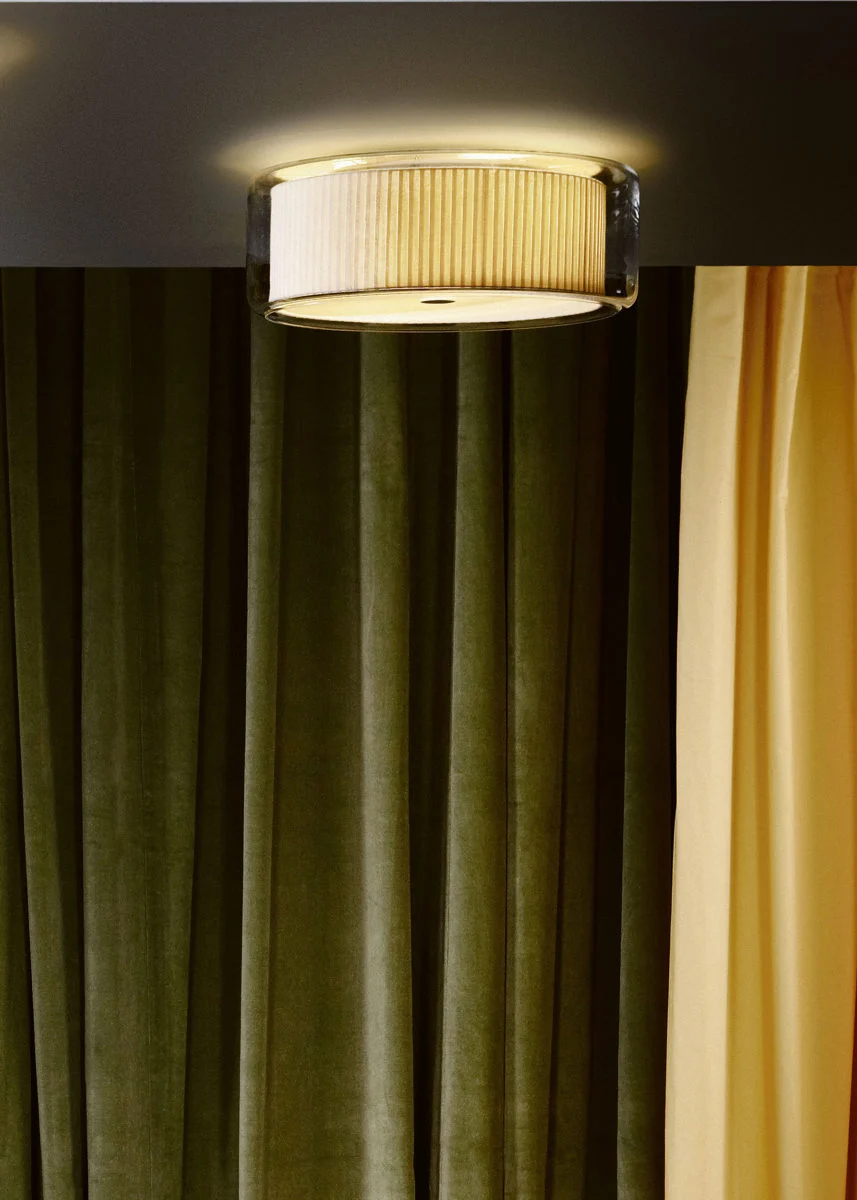 “Contemporary table lamp Mercer by Marset – elegant contrast of warm fabric and clear glass cylinder”