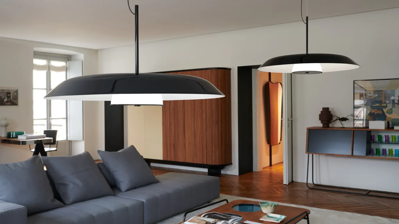 “Iride by Oluce contemporary designer lighting – sculptural wall fixture with iridescent glass and ambient halo effect”