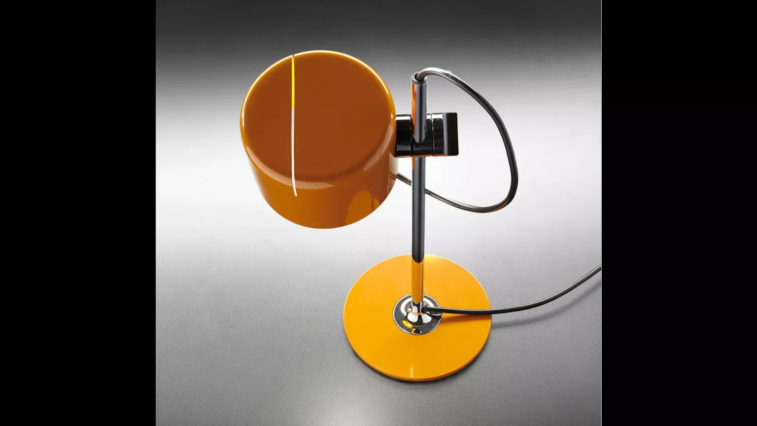 “Mini Coupé by Oluce stylish modern lamp – small-scale table lamp with arched chrome stem and bold silhouette”
