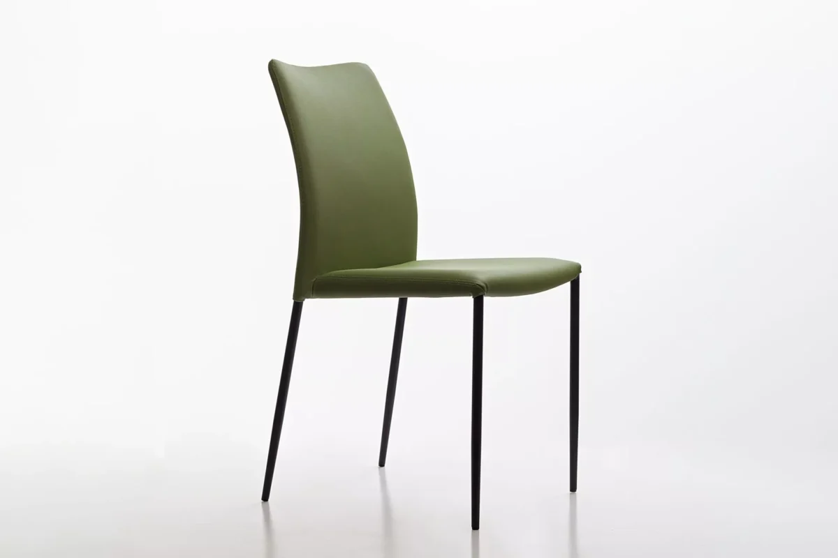Peressini Pola chair in emerald green upholstery with slim black metal legs, shown against a neutral studio backdrop.