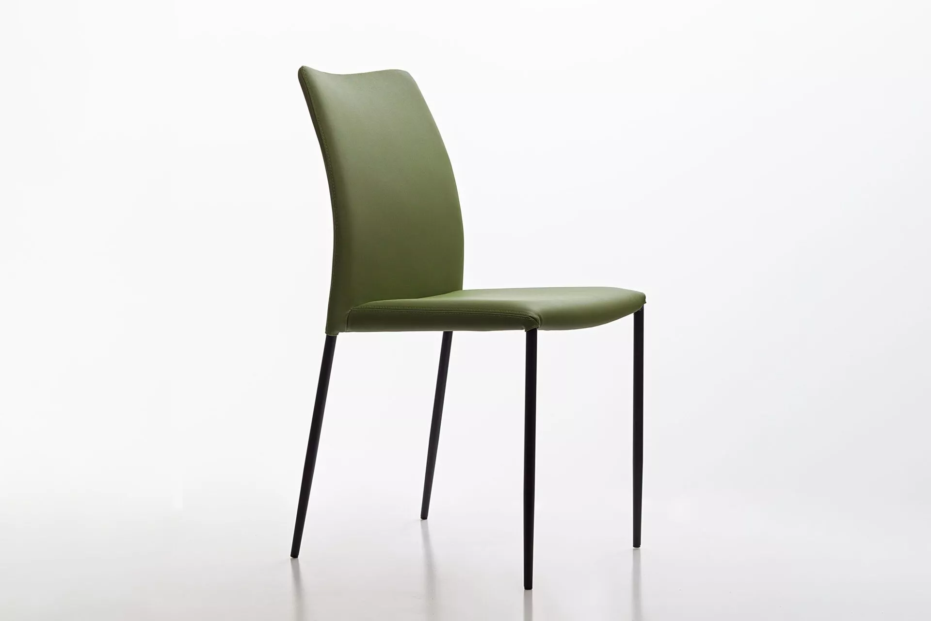 Peressini Pola chair in emerald green upholstery with slim black metal legs, shown against a neutral studio backdrop.