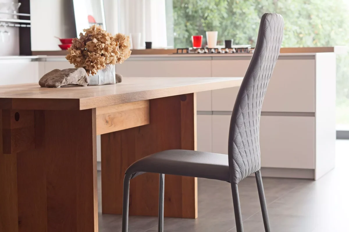 Swing 1H dining chair by Peressini featuring a high, gently curved backrest and fully upholstered seat in soft fabric.