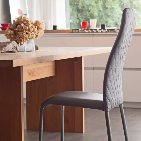 Swing 1H dining chair by Peressini featuring a high, gently curved backrest and fully upholstered seat in soft fabric.