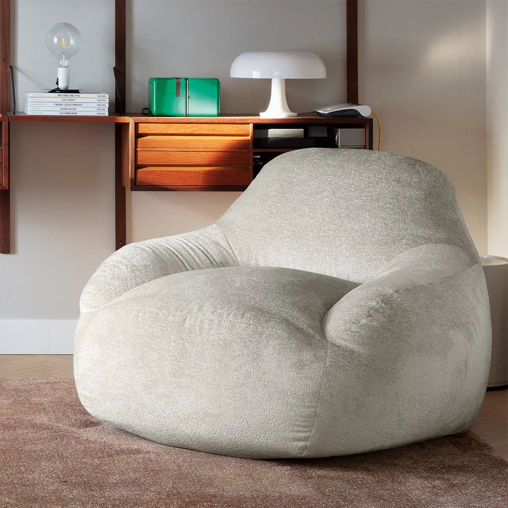 “Side view of TENDER armchair by Connubia – modern lounge chair with padded seat, curved backrest, and metal legs”