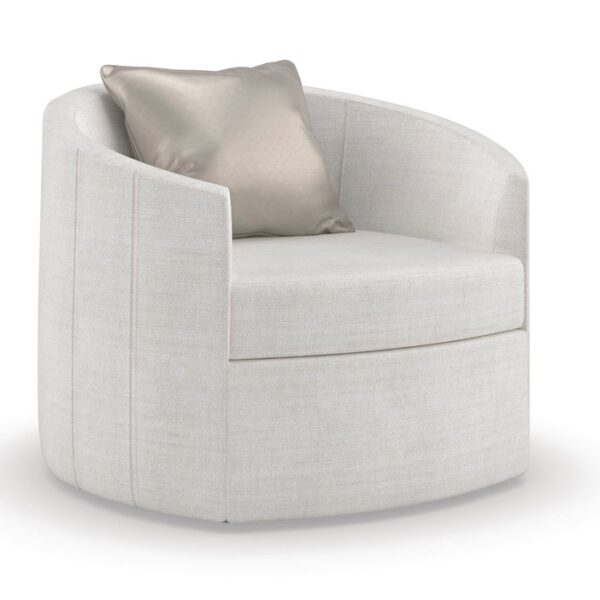 The Caracole "You Complete Me" swivel accent chair, featuring a softly rounded silhouette, pleated seams, upholstered in an easy-care chenille performance fabric (often in a light or neutral tone), and designed to float above a recessed plinth base in an Almost Black finish. A feather-down throw pillow often adds a luxurious touch.