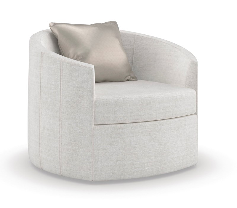 The Caracole "You Complete Me" swivel accent chair, featuring a softly rounded silhouette, pleated seams, upholstered in an easy-care chenille performance fabric (often in a light or neutral tone), and designed to float above a recessed plinth base in an Almost Black finish. A feather-down throw pillow often adds a luxurious touch.