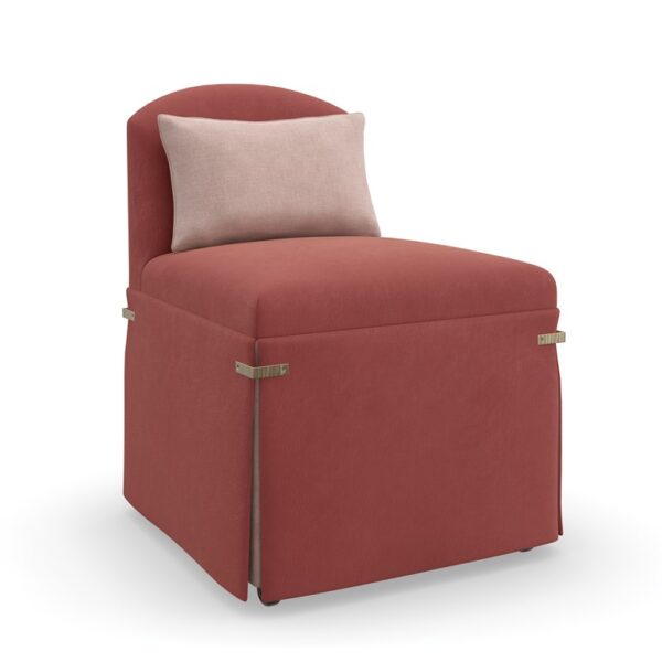 "Bustle Chair by Caracole in dusty rose fabric, featuring a low camelback and dressmaker skirt, cinched with Brushed Gold metal brackets, and equipped with casters for mobility."