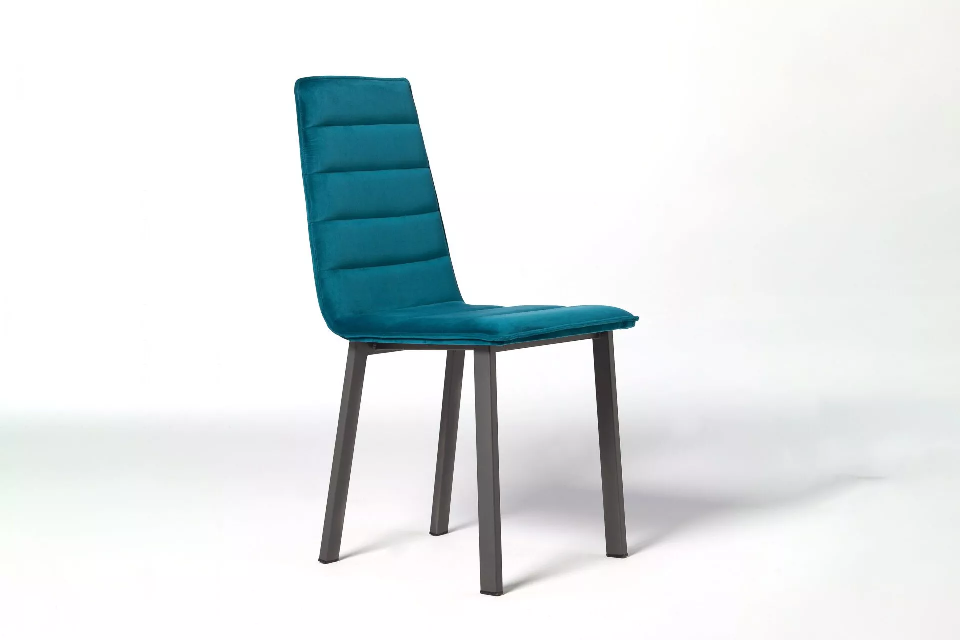 Wind Chair by Peressini in soft beige leatherette with vertical quilting detail on the backrest and slim black metal legs on a hardwood floor.