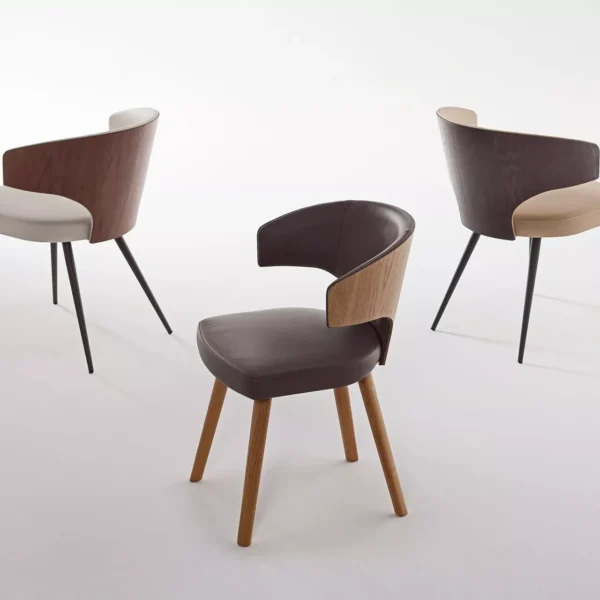 Wing W chair by Peressini with a high, winged backrest and slim metal legs upholstered in dark fabric.