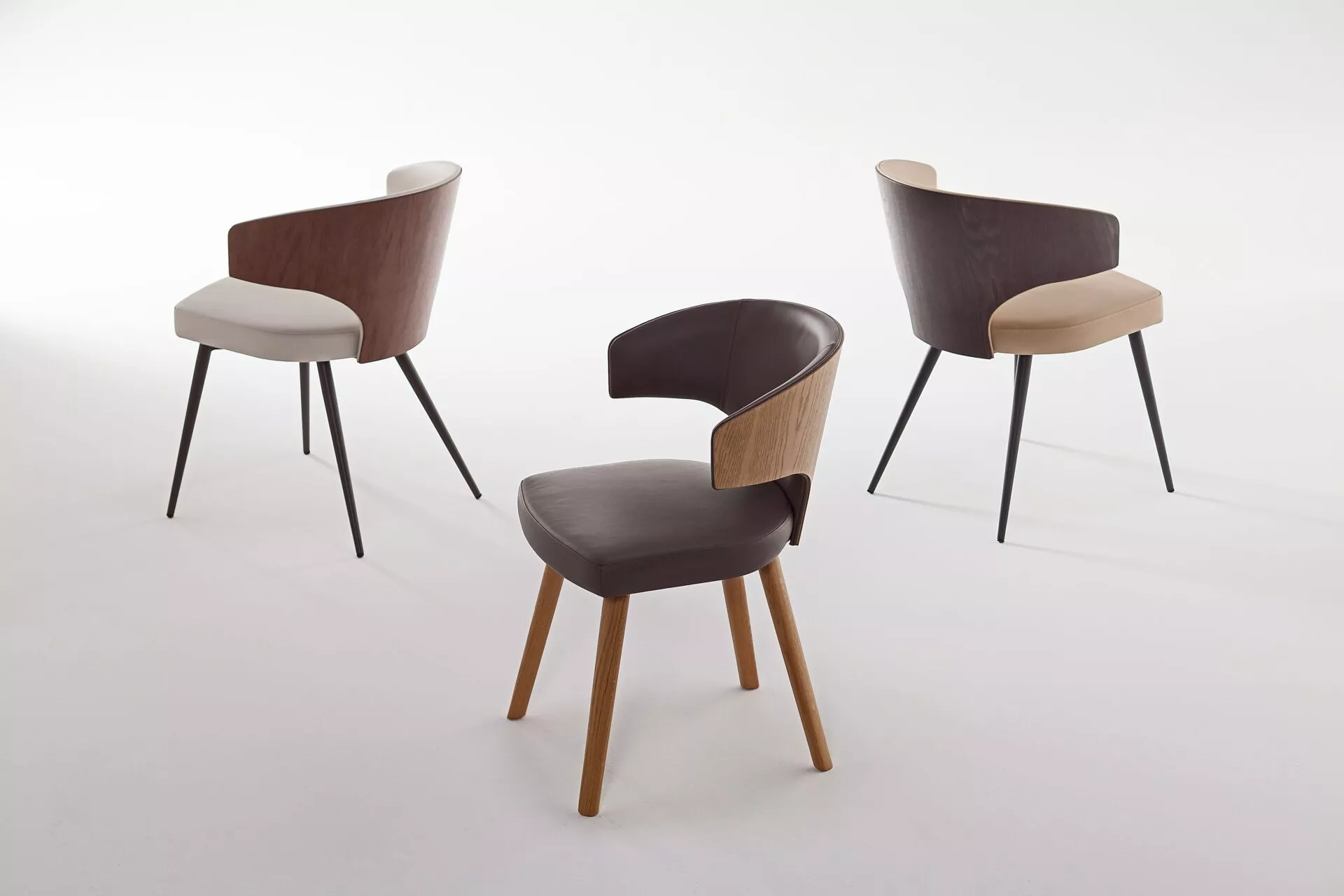 Wing W chair by Peressini with a high, winged backrest and slim metal legs upholstered in dark fabric.