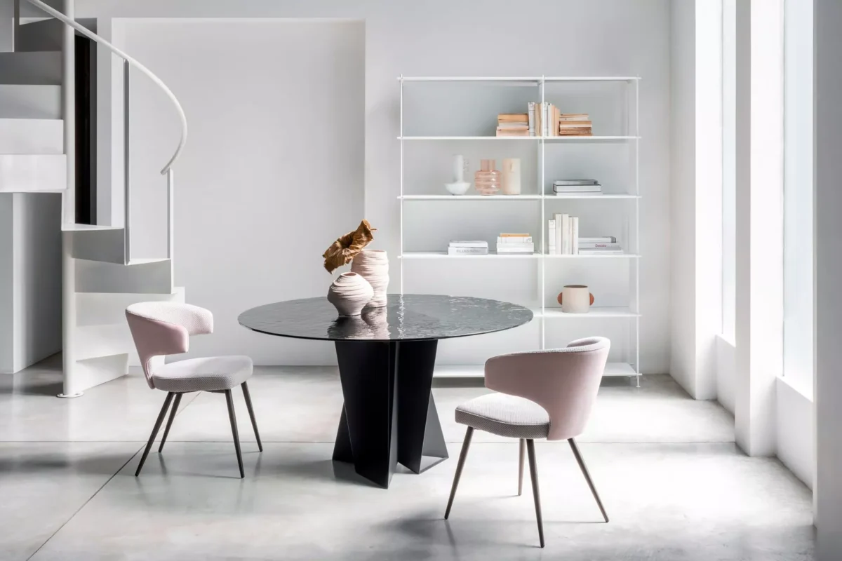 Wing chair by Peressini featuring a high, winged backrest and slim metal legs, upholstered in soft grey fabric.