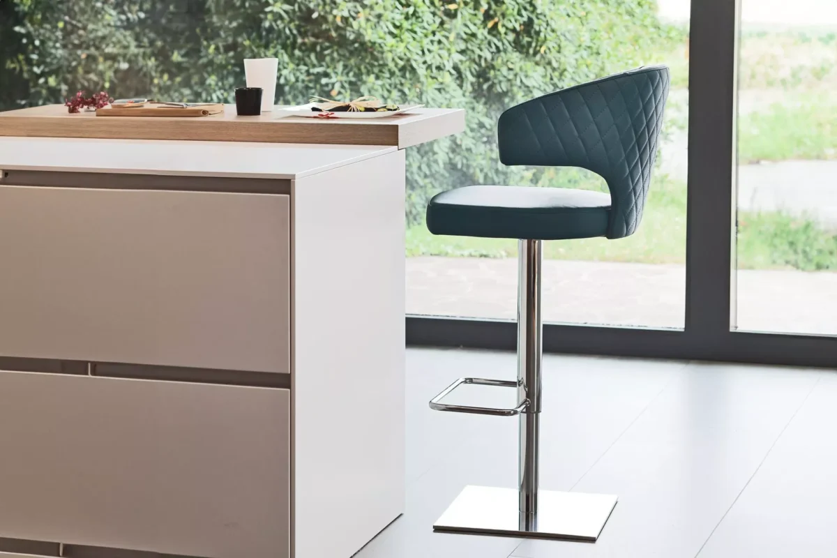 Wing chair by Peressini with tall, winged backrest and slender black metal legs, upholstered in soft grey fabric.