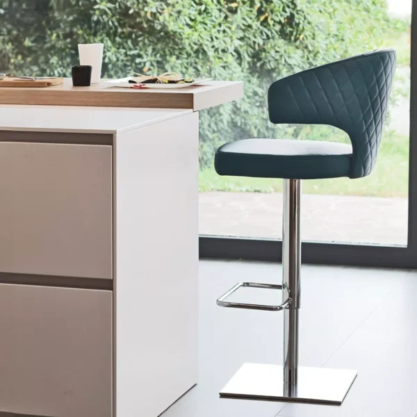 Wing chair by Peressini with tall, winged backrest and slender black metal legs, upholstered in soft grey fabric.