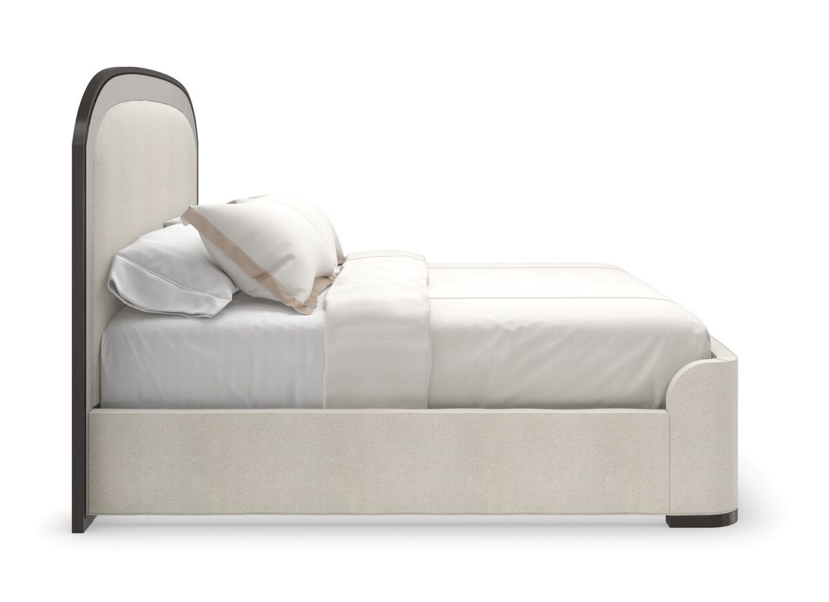 A WANDERLUST King Bed by Caracole in a well-appointed bedroom, demonstrating its ability to anchor the space with its grand proportions and luxurious details.