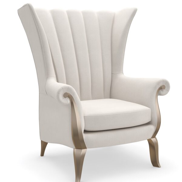 The Caracole Valentina Accent Chair, a sophisticated wing chair with a tall channel-tufted back, wood-trimmed roll arms, upholstered in a light cream pin-dot fabric, and featuring exposed wood details in a Golden Shimmer finish.